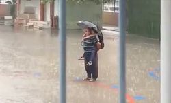 Adana'da bir kişi sağanakta sırtına aldığı torunuyla İstiklal Marşı'nı okudu
