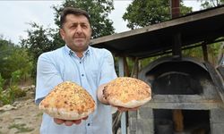İmam taş fırında pişirdiği ekmekleri köylülere ikram ediyor